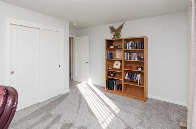 interior space featuring a closet, carpet flooring, and baseboards