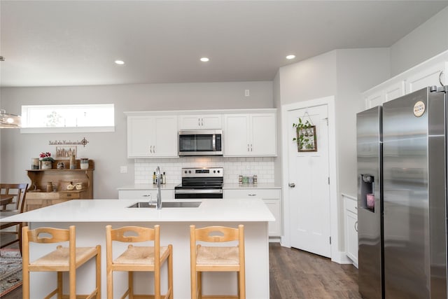 kitchen with recessed lighting, stainless steel appliances, light countertops, white cabinetry, and backsplash