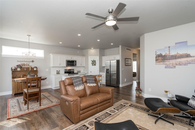 living room featuring visible vents, baseboards, recessed lighting, dark wood-style flooring, and ceiling fan with notable chandelier