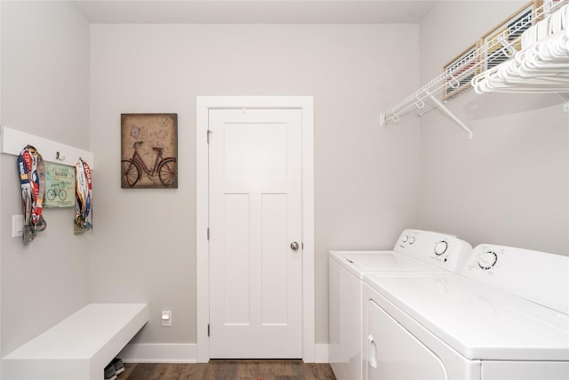 laundry area featuring laundry area, separate washer and dryer, dark wood-style flooring, and baseboards