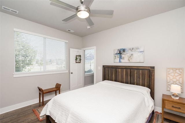 bedroom with a ceiling fan, baseboards, visible vents, and dark wood-style flooring