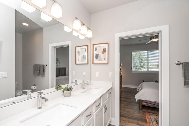 full bathroom featuring double vanity, toilet, wood finished floors, and a sink