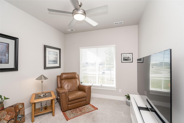 sitting room with carpet, a ceiling fan, visible vents, and baseboards