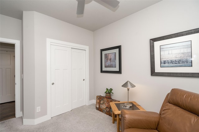 sitting room with baseboards, carpet floors, and a ceiling fan