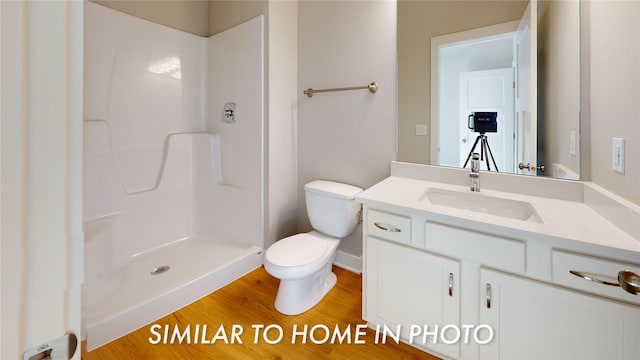 full bath featuring toilet, vanity, walk in shower, and wood finished floors