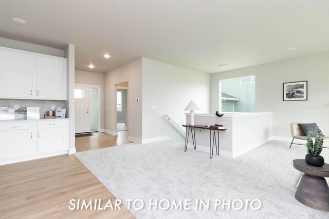 10022 NW 68th Ave, Johnston, IA 50131 - kitchen with white cabinets, recessed lighting, baseboards, light wood finished floors, and tasteful backsplash