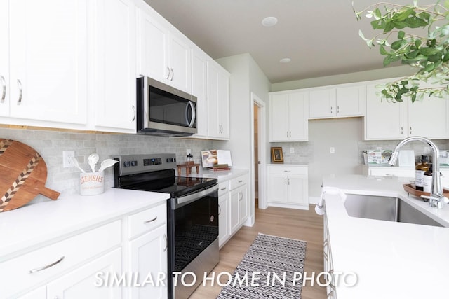 10022 NW 68th Ave, Johnston, IA 50131 - kitchen with appliances with stainless steel finishes, a sink, white cabinets, and light countertops