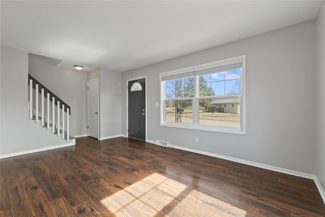 entryway featuring stairway, visible vents, baseboards, and wood finished floors