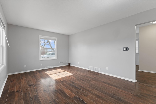 empty room featuring visible vents, baseboards, and wood finished floors