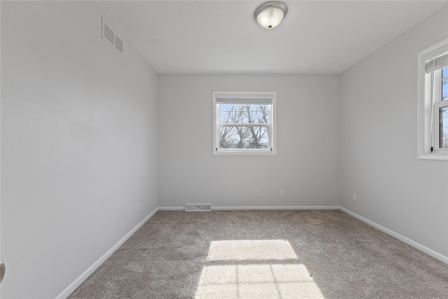 empty room with visible vents, baseboards, and carpet floors