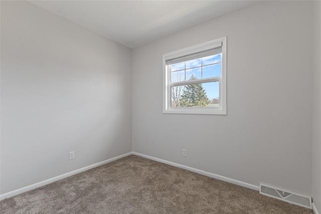 carpeted spare room with visible vents and baseboards