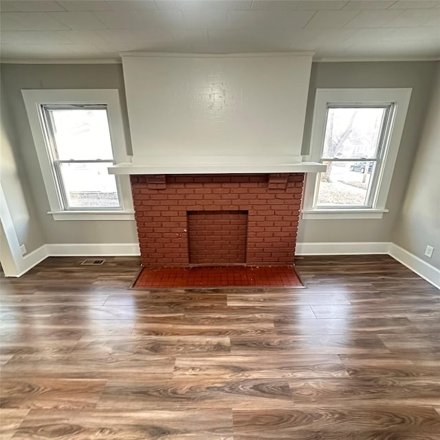 unfurnished living room featuring a fireplace, crown molding, and wood finished floors