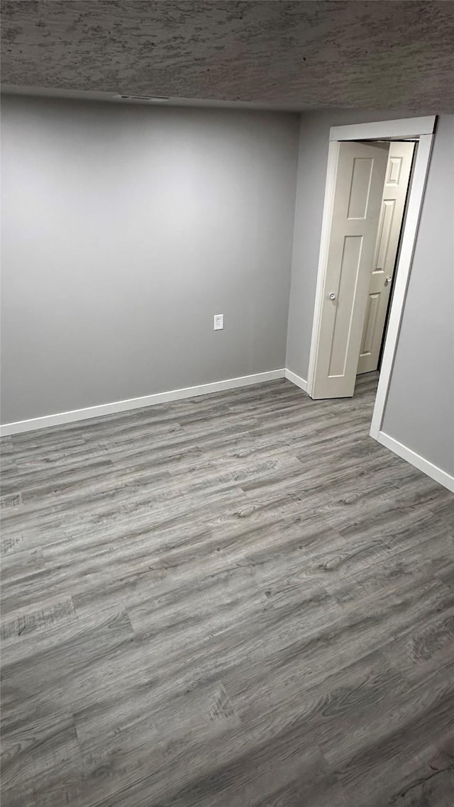 unfurnished room featuring baseboards and dark wood finished floors