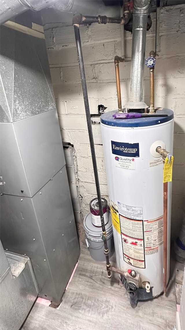 utility room featuring gas water heater and heating unit