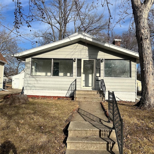 bungalow-style home with entry steps and a chimney