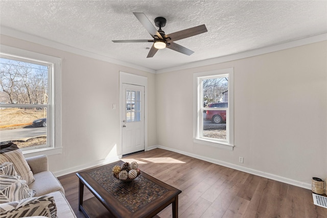 living area featuring a healthy amount of sunlight, baseboards, and wood finished floors