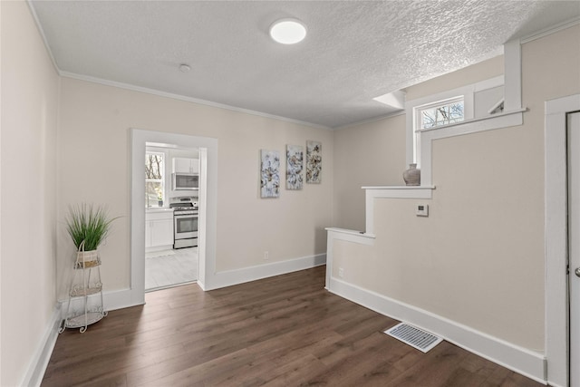 interior space featuring visible vents, plenty of natural light, a textured ceiling, and dark wood finished floors