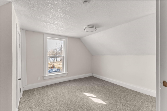 additional living space with baseboards, carpet flooring, a textured ceiling, and lofted ceiling