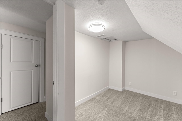 bonus room with lofted ceiling, carpet flooring, baseboards, and a textured ceiling