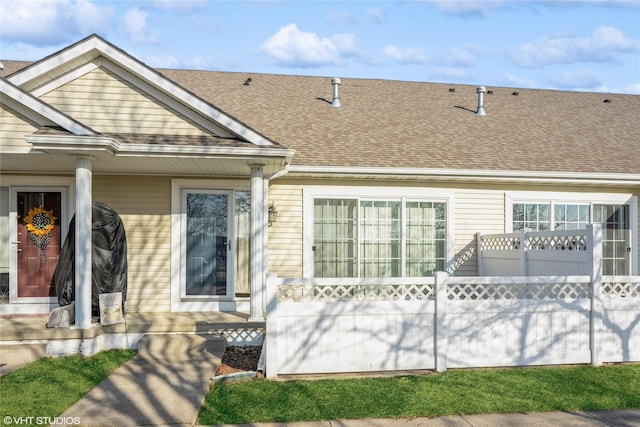 view of front of property featuring roof with shingles and fence