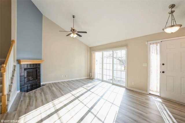 unfurnished living room featuring baseboards, high vaulted ceiling, a ceiling fan, and wood finished floors