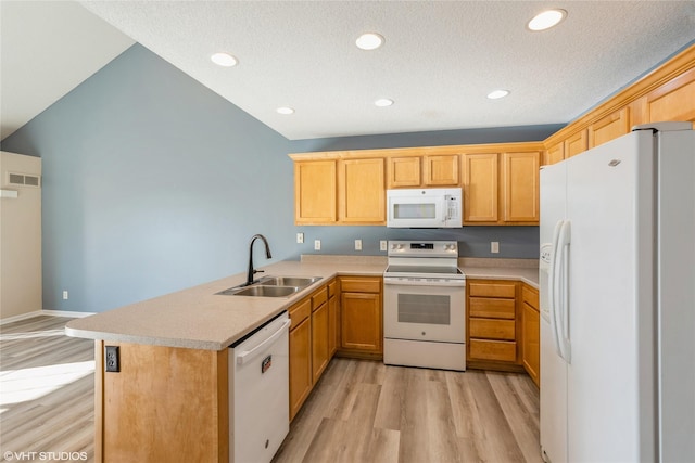 kitchen featuring white appliances, a peninsula, light wood-style flooring, a sink, and light countertops