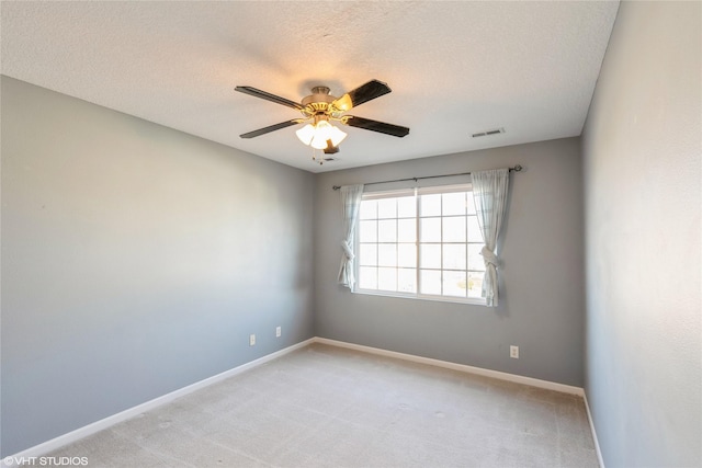 unfurnished room with visible vents, light carpet, a textured ceiling, baseboards, and ceiling fan