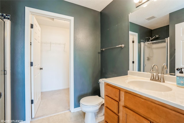 full bath featuring vanity, visible vents, a stall shower, a spacious closet, and toilet