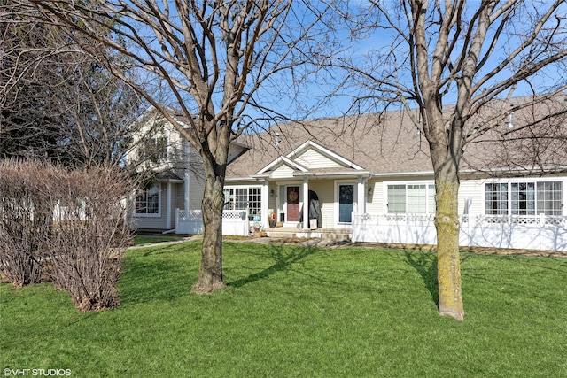 view of front facade featuring a porch, a front yard, and roof with shingles