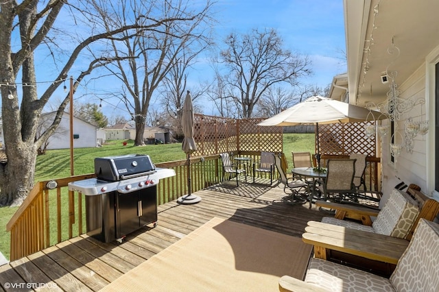 wooden deck with outdoor dining area, a lawn, and a grill