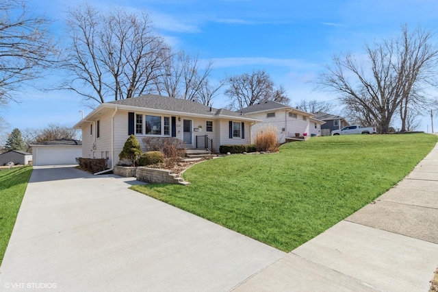 ranch-style home featuring an outbuilding, a front yard, and a detached garage