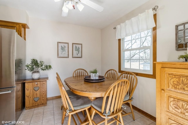 dining area with light tile patterned flooring, a ceiling fan, and baseboards