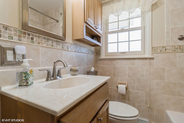 bathroom featuring toilet, vanity, tile walls, and walk in shower