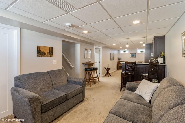 living room with wet bar, recessed lighting, light colored carpet, and a drop ceiling