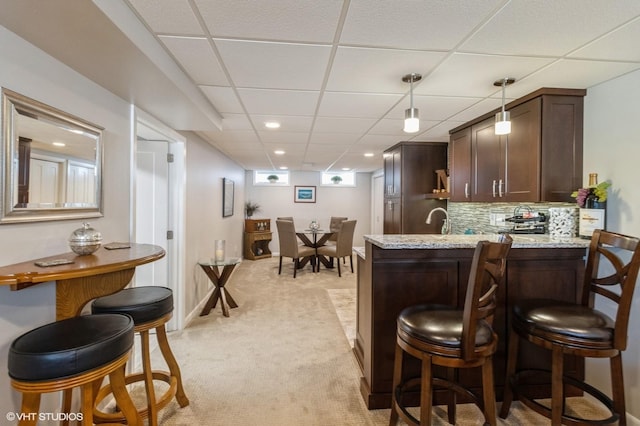 bar with decorative light fixtures, a drop ceiling, tasteful backsplash, recessed lighting, and light colored carpet