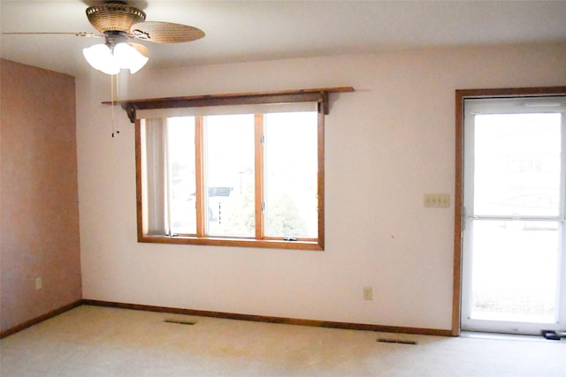 spare room with visible vents, carpet flooring, baseboards, and ceiling fan