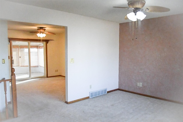 unfurnished room with baseboards, visible vents, carpet floors, and ceiling fan