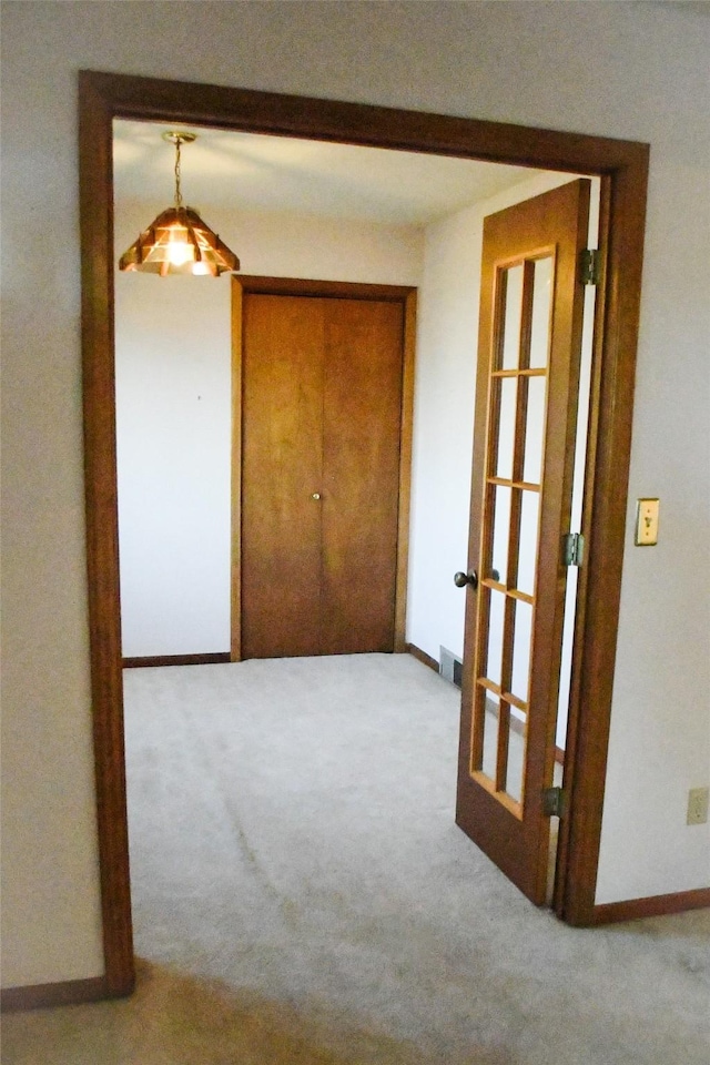 hallway with carpet flooring, french doors, and baseboards