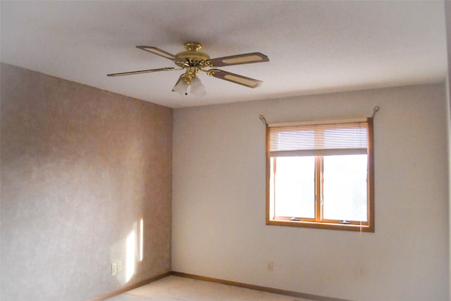 spare room with baseboards and ceiling fan