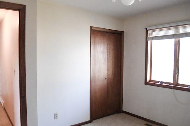 unfurnished bedroom with a closet and baseboards