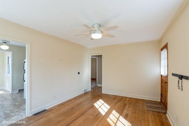 unfurnished room featuring visible vents, ceiling fan, baseboards, ornamental molding, and light wood-style floors