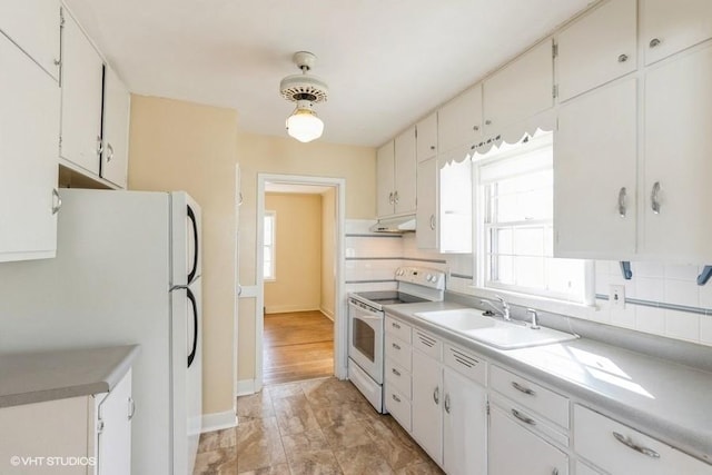 kitchen with white cabinetry, white appliances, backsplash, and a sink