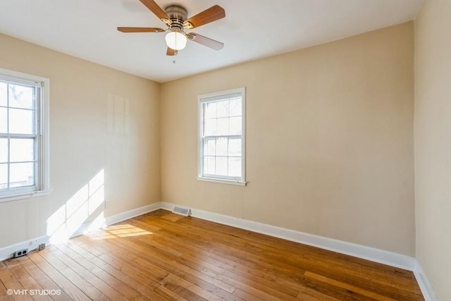 unfurnished room featuring visible vents, baseboards, light wood-style floors, and a ceiling fan