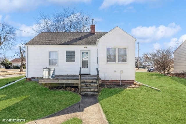 bungalow featuring a front yard, a chimney, and a shingled roof