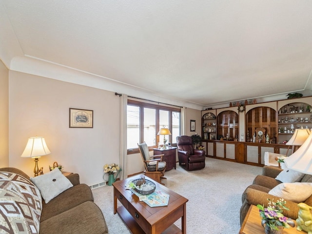 living area with visible vents and carpet