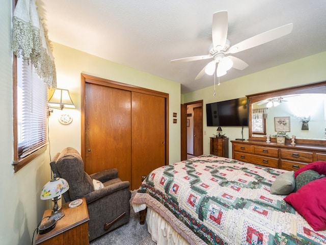 bedroom featuring a closet, ceiling fan, and dark carpet