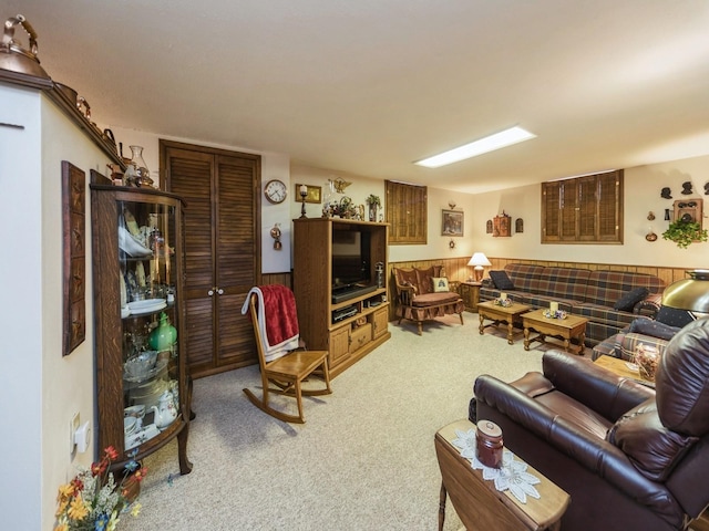 carpeted living area featuring a wainscoted wall