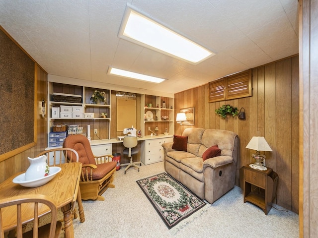 living room featuring built in shelves, carpet, wood walls, and built in desk