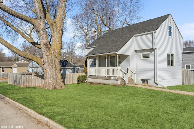 view of front of house with covered porch, roof with shingles, a front yard, and fence