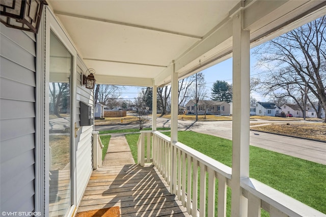 wooden deck with a residential view and covered porch